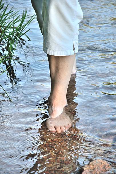 istock woman walking in water 489181348
