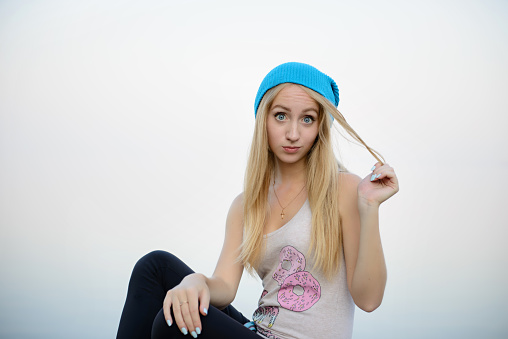 The beautiful girl in a blue cap on walk