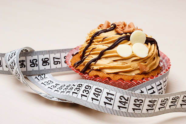 cupcake with measuring tape on table - control room stockfoto's en -beelden