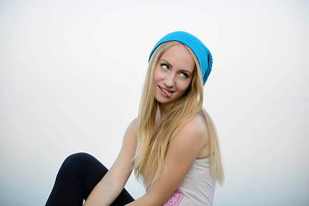 Teenager smiling with clear sky background.