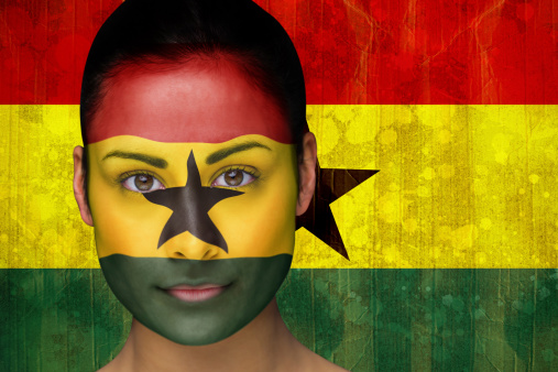 Composite image of beautiful football fan in face paint against ghana flag in grunge effect