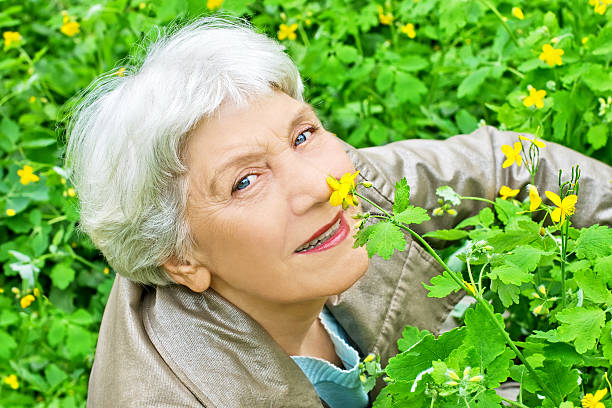 istock beautiful elderly woman sitting on a glade in spring 489190105