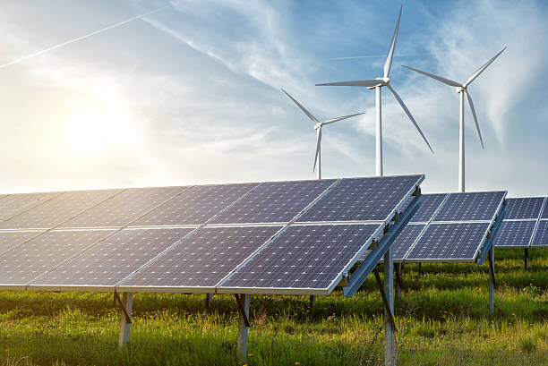 paneles solares y generador de viento en el cielo azul en la puesta de sol - energía sostenible fotos fotografías e imágenes de stock