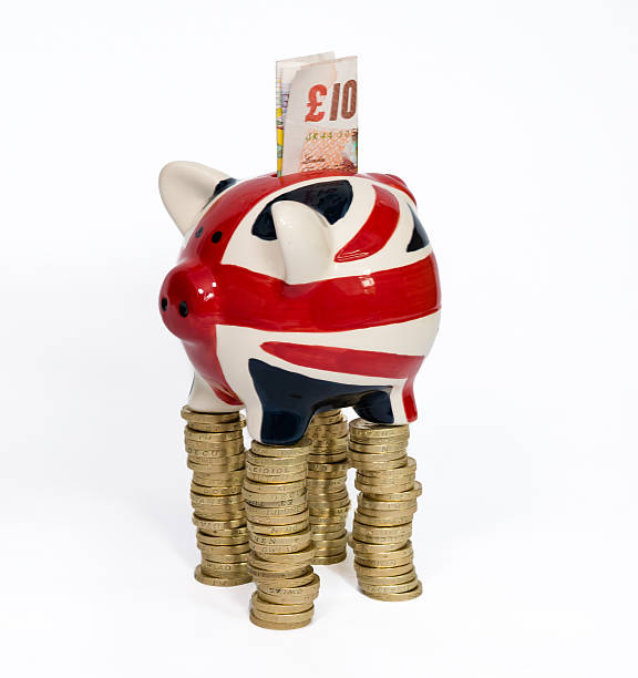 salvadanaio a porcellino su denaro trampoli - british flag currency banking uk foto e immagini stock