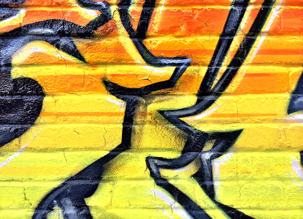 nero e giallo dettaglio di graffiti su un muro di mattoni - orange wall textured paint foto e immagini stock