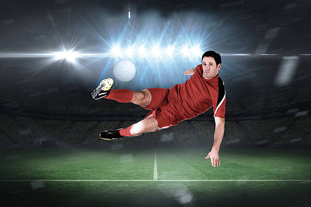istock Football player in red kicking 489195007