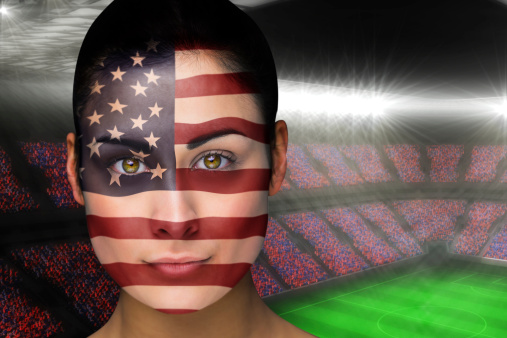 Composite image of beautiful america fan in face paint against large football stadium with fans in blue