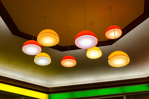 Mid-century (60s or 70s) pendant lamps haging off the ceiling in an urban mall.