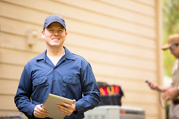 istock Air conditioner repairmen work on home unit. Blue collar workers. 489202018