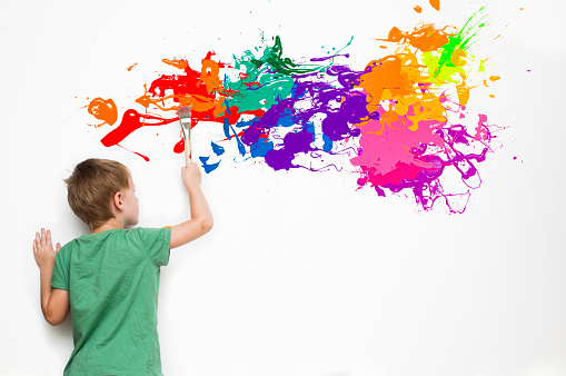 Gifted child drawing an abstract picture with colorful splatters