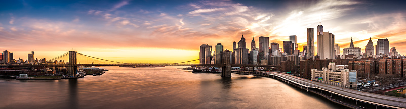 The iconic landmark spans between Brooklyn and the New York Financial District skyline, dominated by the Freedom Tower.