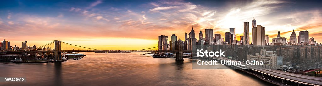 Brooklyn Bridge panorama at sunset The iconic landmark spans between Brooklyn and the New York Financial District skyline, dominated by the Freedom Tower. New York City Stock Photo