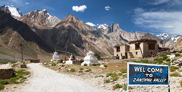 Village in Suru valley and signpost Welcome to Zanskar valley Village in Suru valley and signpost Welcome to Zanskar valley, road from Kargil to Padum, Zanskar valley, Ladakh, Jammu and Kashmir, India monastery religion spirituality river stock pictures, royalty-free photos & images