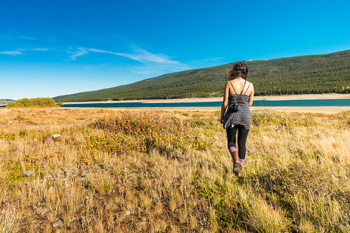 Mujer camina con césped lago paisaje en el Parque Nacional de los Glaciares photo