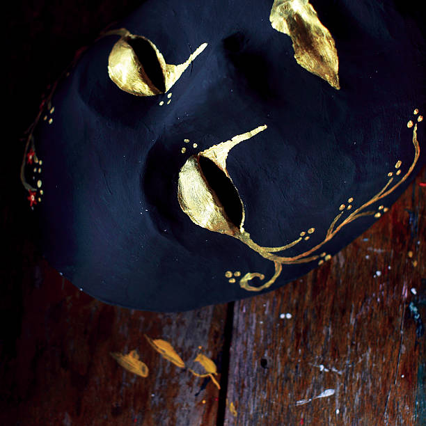 istock Dark full mask with golden pattern on wooden table 489211116