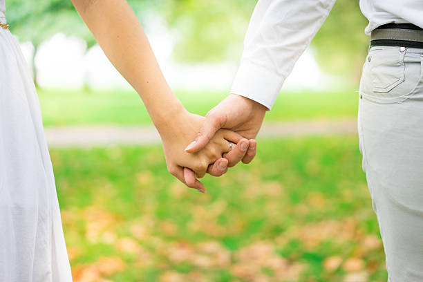 istock young couple holding hands in the park, London. 489212842
