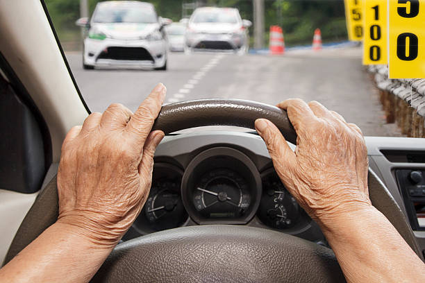 istock Senior woman driving a car on road. 489216348