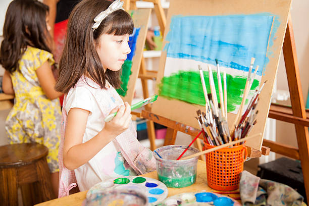 istock Pretty girl looking at her painting 489216418