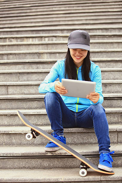 istock young woman skateboarder use her digital tablet sit on stairs 489218843