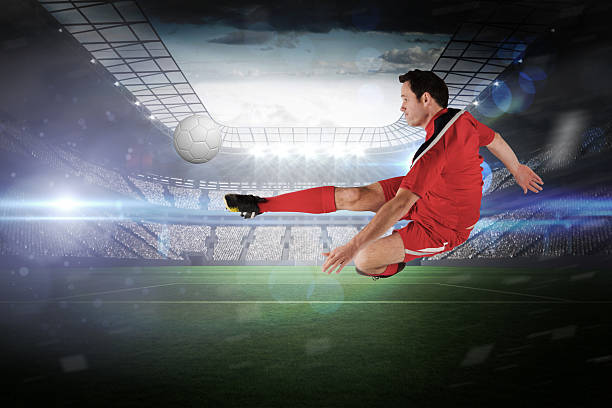 istock Football player in red kicking 489220683