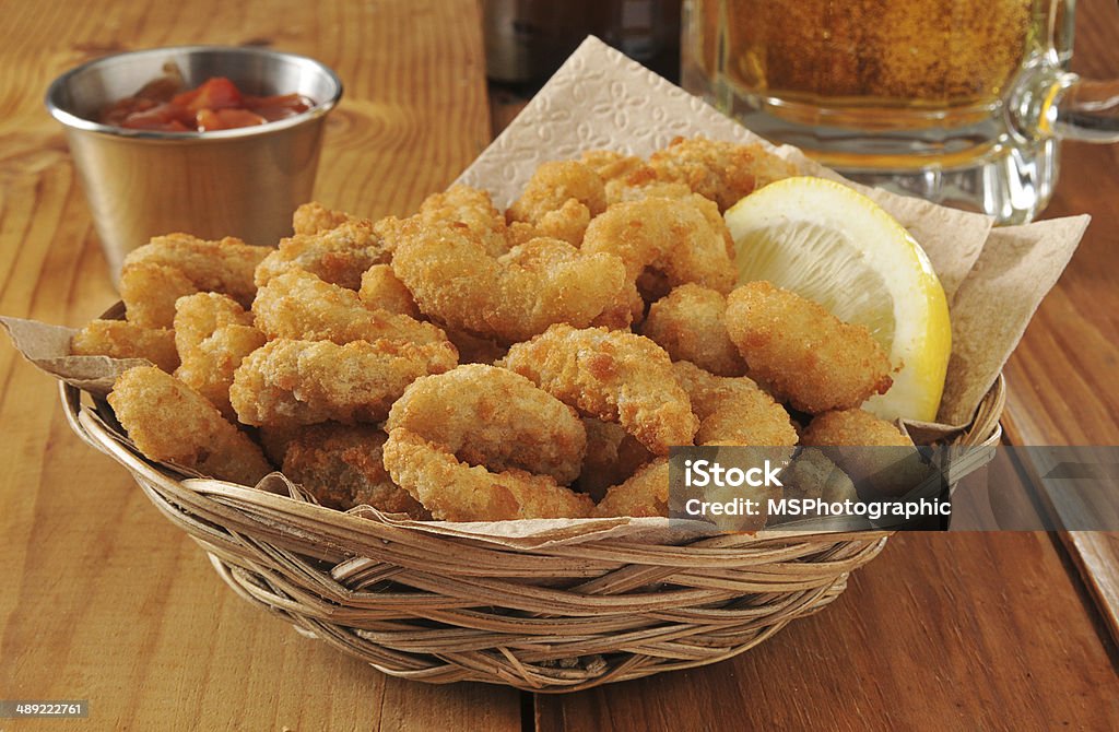 Popcorn shrimp and beer a basket of popcorn shrimp with lemon and cocktail sauce with a mug of beer Shrimp - Seafood Stock Photo