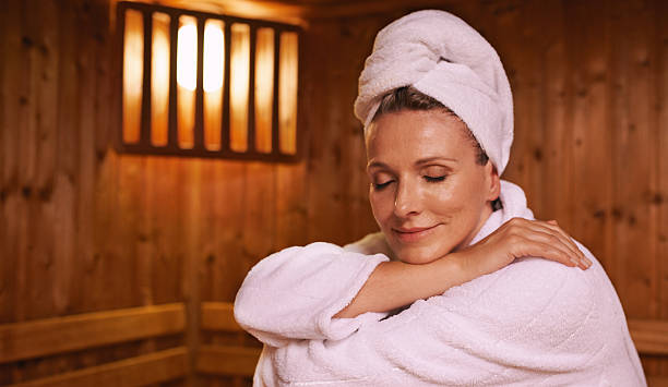Feeling serene in the sauna Shot of a mature woman in a sauna sauna stock pictures, royalty-free photos & images