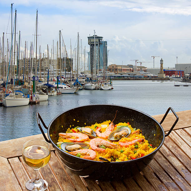 Seafood paella with glass of wine in seaside cafe,port of  Barcelona