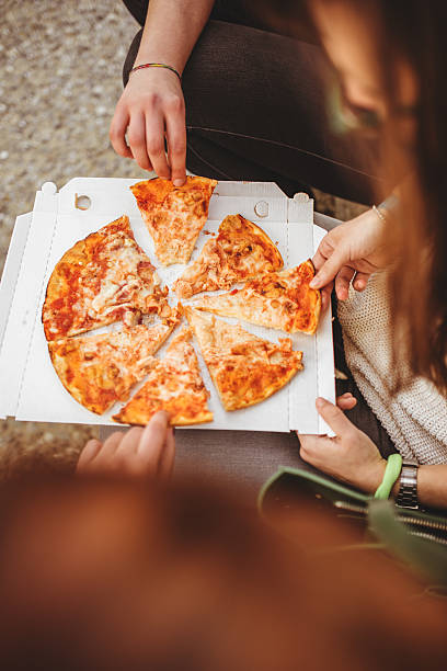 istock group of friends eating pizza togetherness 489225817