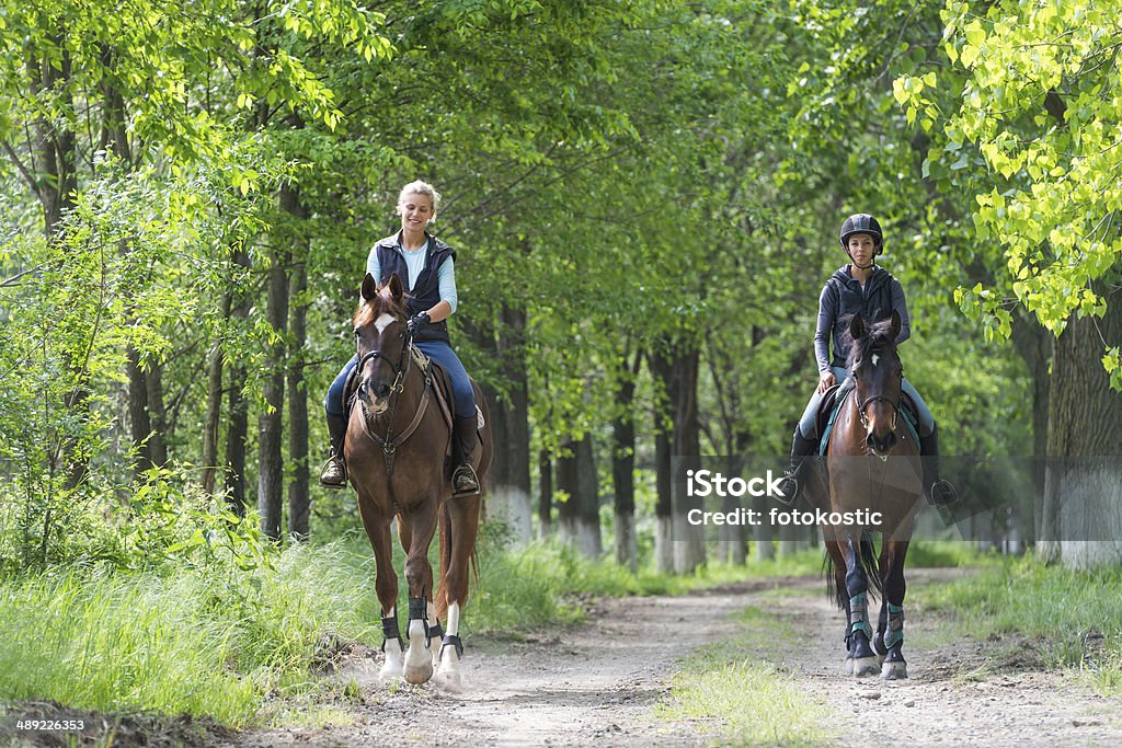 Girls on horseback riding Two a young girls on horseback riding Horseback Riding Stock Photo