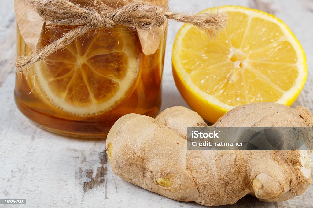 Fresh lemon, honey and ginger on wooden table, healthy food Lemon with honey in glass jar, fresh lemon and ginger on old wooden table, concept of healthy food, nutrition and strengthening immunity 2015 Stock Photo