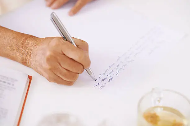 Close-up of senior woman writing a letter to her beloved, selective focus