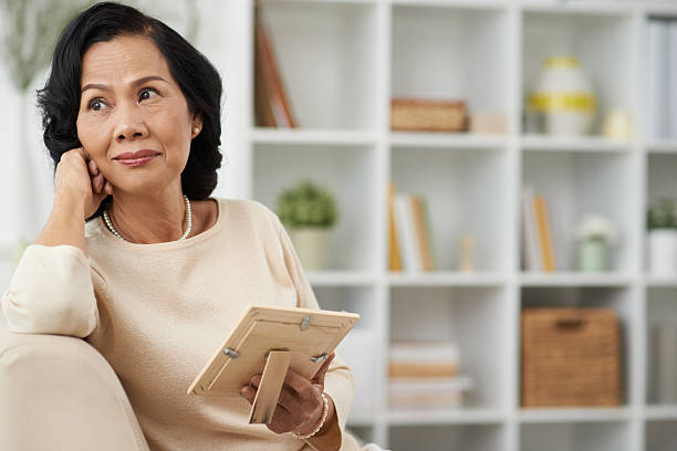 Thoughtful woman Pretty mature woman with a photo in her hands looking thoughtfully to the side widow stock pictures, royalty-free photos & images