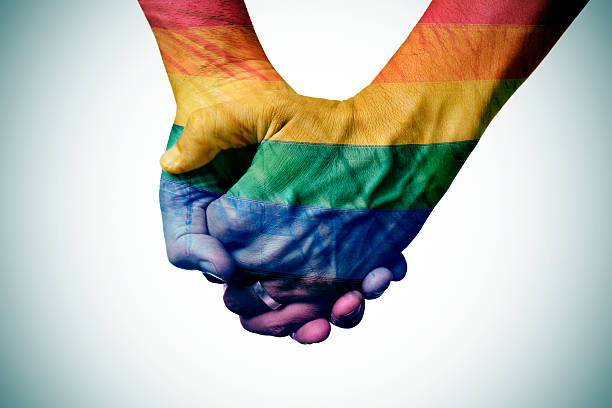 istock gay couple holding hands, patterned as the rainbow flag 489251276