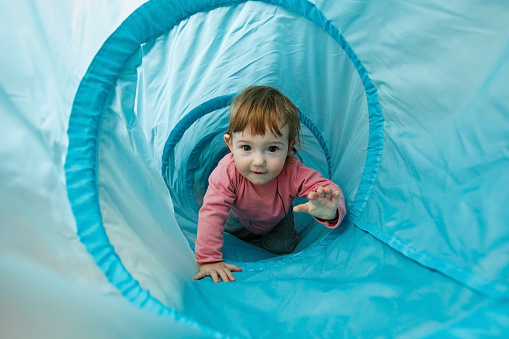Pequeño niño pequeño jugando en un túnel tubo photo
