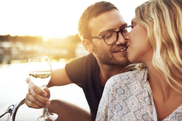 Couple Kissing Gently Couple Kissing Gently while Enjoying a glass of Wine couple punting stock pictures, royalty-free photos & images