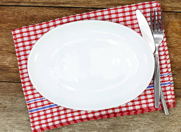 istock Empty plate, silverware and towel over wooden table background. 489254448