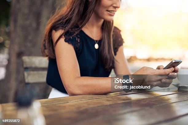 Woman Using Mobile Phone At Cafe Stock Photo - Download Image Now - Restaurant, Telephone, Cafe