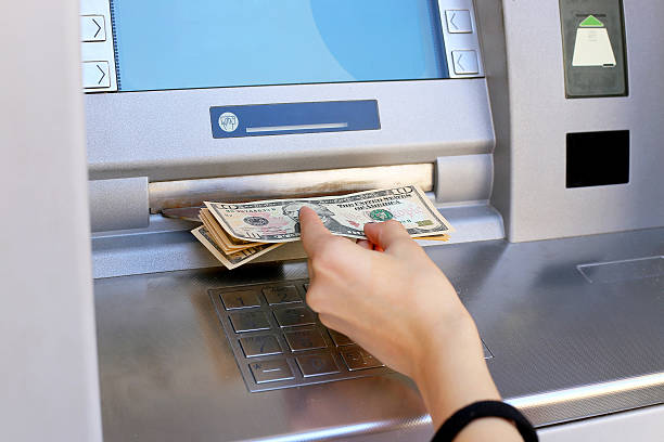 inserting a credit card to ATM woman hand showing dollar banknotes in front of the atm bank deposit slip photos stock pictures, royalty-free photos & images