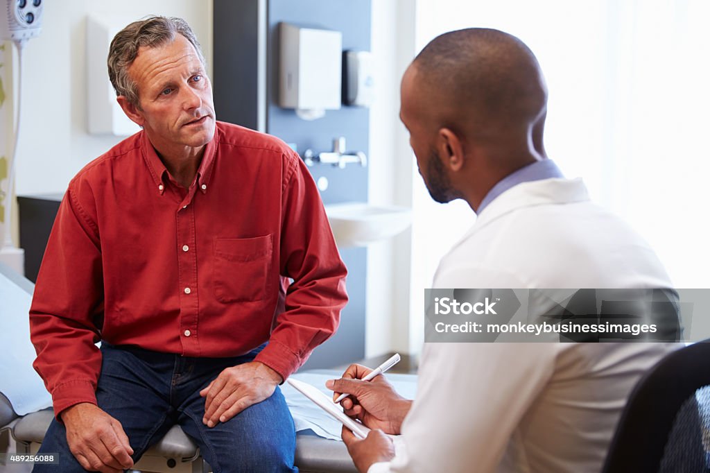 Male Patient And Doctor Have Consultation In Hospital Room Doctor Stock Photo