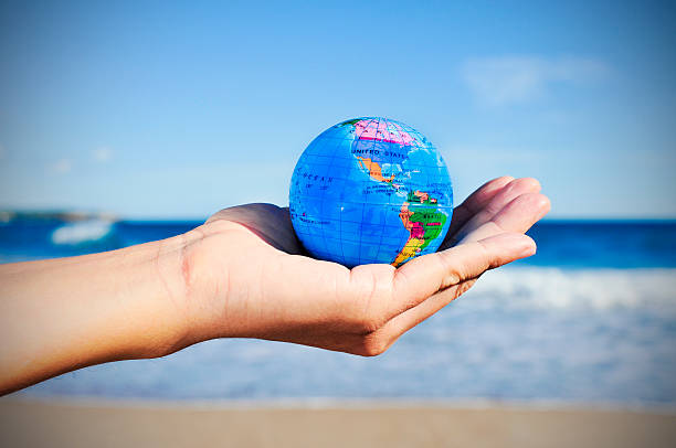 istock young man with a world globe in his hand, vignetted 489256160