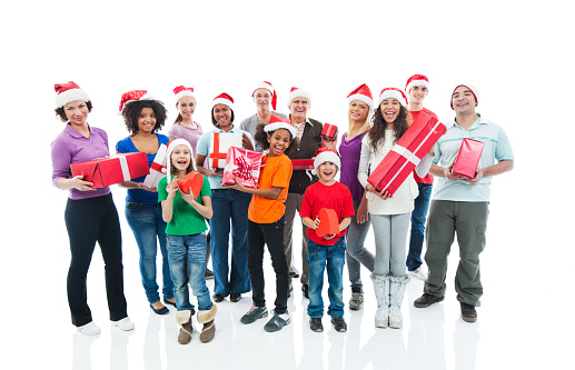 Large group of cheerful people wearing Santa's hats and holding Christmas presents. They are looking at camera. Isolated on white.