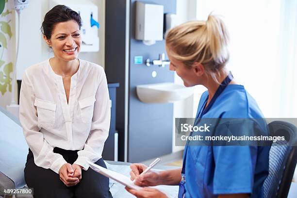Female Patient And Doctor Have Consultation In Hospital Room Stock Photo - Download Image Now