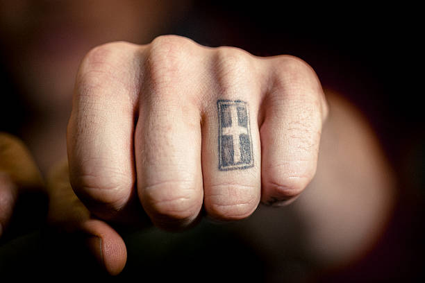 istock Man's hand with cross tattoo 489258212