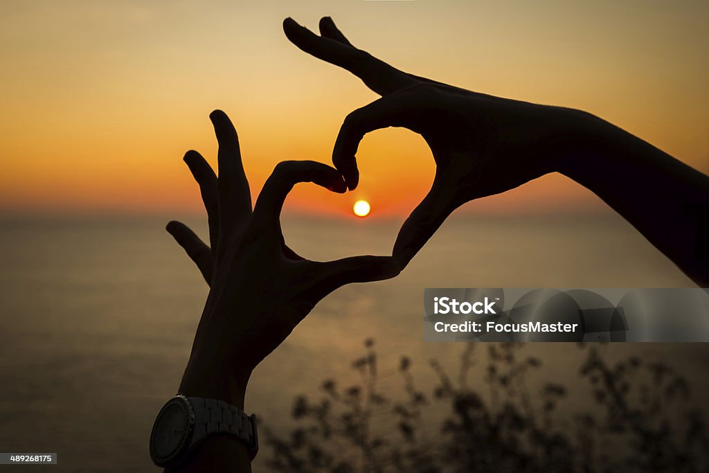 sunset heart heart shape hand silhouette with sunset Backgrounds Stock Photo