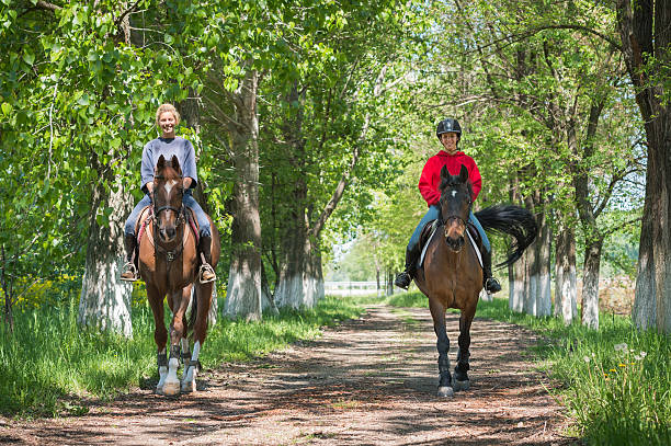 Two a young girls on horseback riding