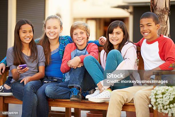 Group Of Children Sitting On Bench In Mall Stock Photo - Download Image Now - Child, 10-11 Years, 12-13 Years