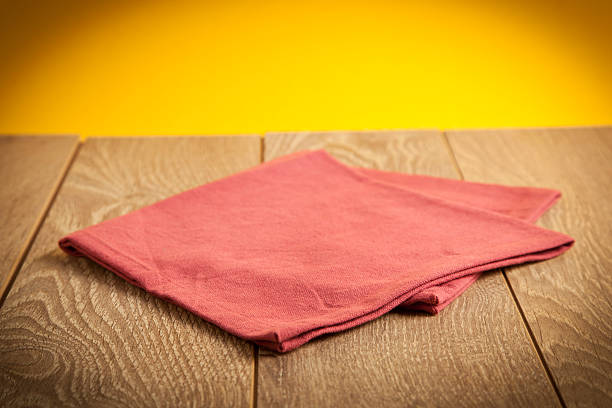 Retro background with wooden table and napkin over yellow wall