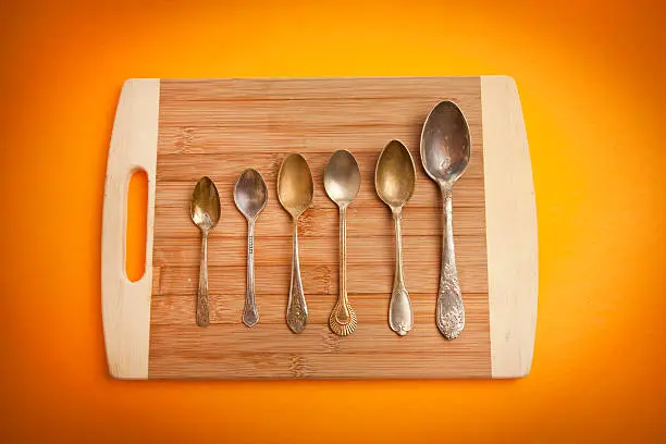 Vintage spoons on wooden chopping board