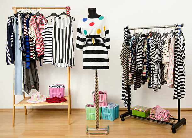 istock Dressing closet with striped clothes arranged on hangers. 489274463