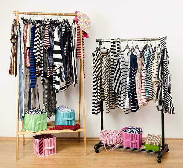 istock Dressing closet with striped clothes arranged on hangers. 489274469